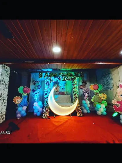 A Cocomelon-themed baby shower decoration with a lighted moon prop. This setup is perfect for parents who are fans of the popular kids' show.