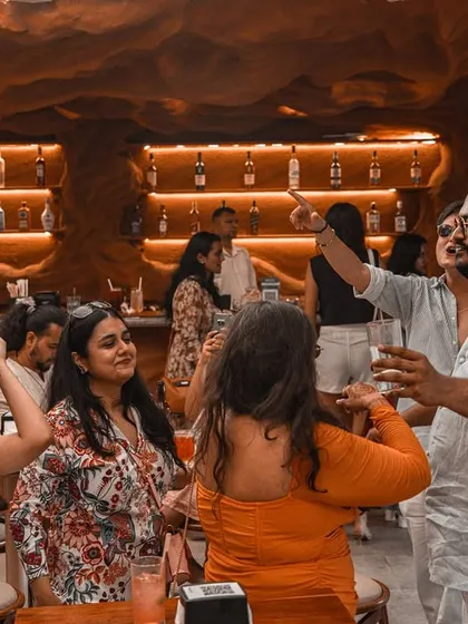 Guests enjoying a Sunday brunch, with some dancing and others relaxing. The music is curated to fit this multi-faceted social environment.