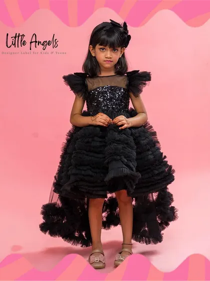 The "Spicy Black" dress features a high low hem with layers of structured ruffles and a sequined bodice.