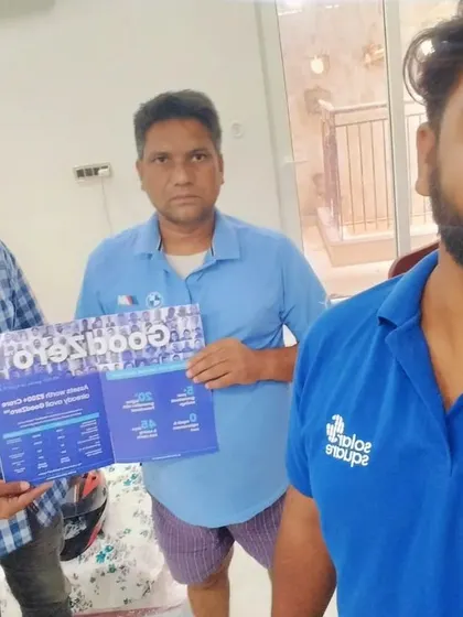 Our team with a customer holding our "GoodZero" brochure.