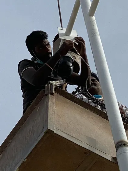 For high-up installations, I use proper equipment to reach difficult spots safely. Here my team is mounting a Tiandy PTZ camera on a building corner.