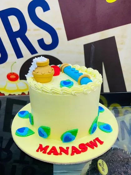 A 1.5kg cake celebrating Krishna Janmashtami, with a fondant flute and peacock feathers.