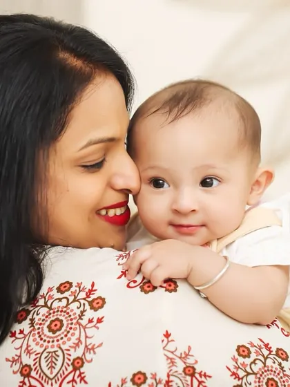 A sweet portrait of a mother and her baby looking over her shoulder. The baby's curious expression and the mother's gentle smile make this a precious memory.