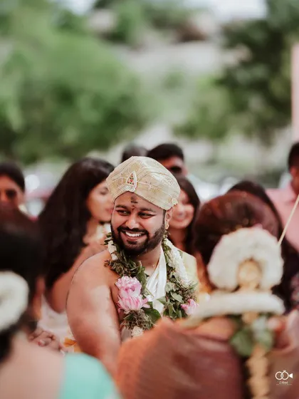 A candid shot of the groom smiling happily during his wedding ceremony.