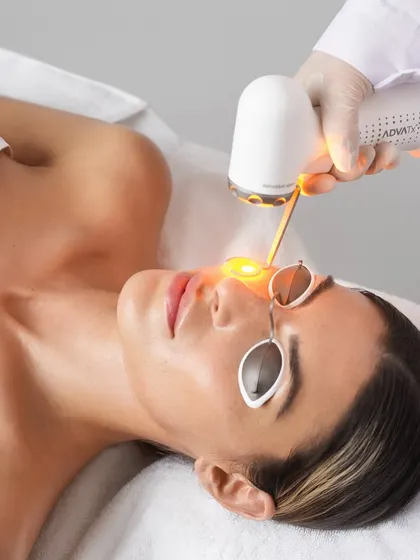 A client undergoing an ADVATx laser session. The treatment is comfortable, and the protective eyewear ensures safety as the yellow light works to correct skin imperfections.