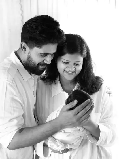 A black and white version of a classic newborn family portrait, emphasizing the light, emotion, and connection between the three of them.