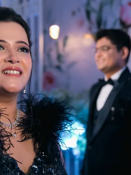 The bride's radiant smile during the reception, with her groom looking on admiringly in the background. A beautiful, storytelling shot.
