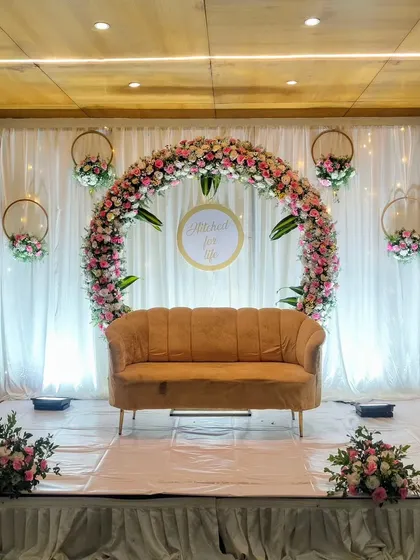 A simple and modern engagement stage with a circular floral arch.