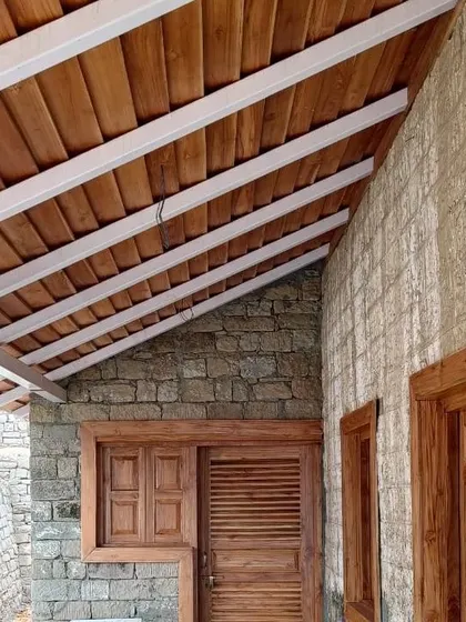 **Haat Market, Shyamlatal:** A close-up of the material palette, showing the texture of the local stone walls, wooden doors and windows, and the exposed-beam ceiling. The craftsmanship is simple, honest, and rooted in place.