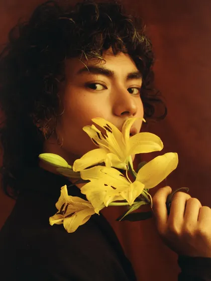 An artistic and soft portrait of a male model with flowers. This challenges traditional masculinity and shows a versatile, sensitive side.