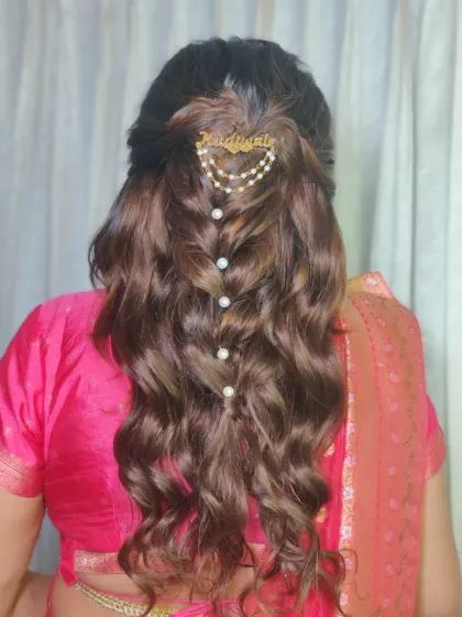 A detailed look at her hairstyle, featuring soft waves and a personalized 'dulhaniya' hair accessory.