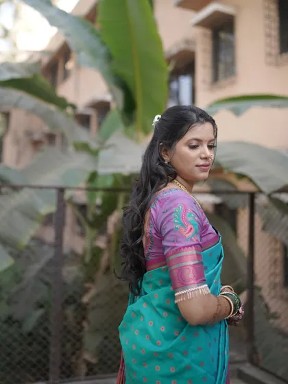 A lovely outdoor shot showing the complete look from the back. The hairstyle with soft waves is a key part of the overall bridal ensemble.