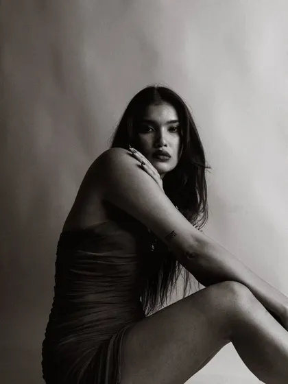 A close-up black and white portrait that is both intense and intimate. The focus is entirely on her captivating gaze.