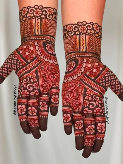 This dense Indian mehendi design covers the entire palm with a variety of traditional patterns. The mix of bold lines and fine details creates a rich and textured look.