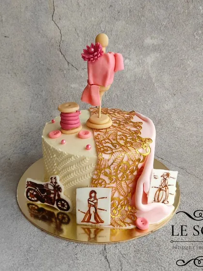This cake celebrates a fashion designer's dream. The half-kg Milk Chocolate Truffle cake is decorated with a mannequin, a thread spool, sketches, and a beautiful gold lace fabric effect.