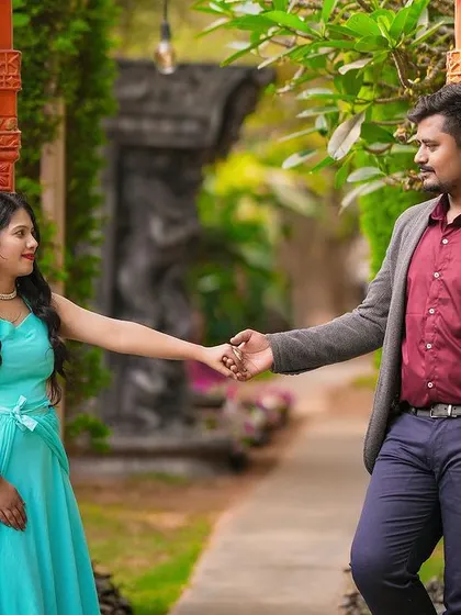 A classic pre-wedding pose with the couple holding hands between two ornate pillars.