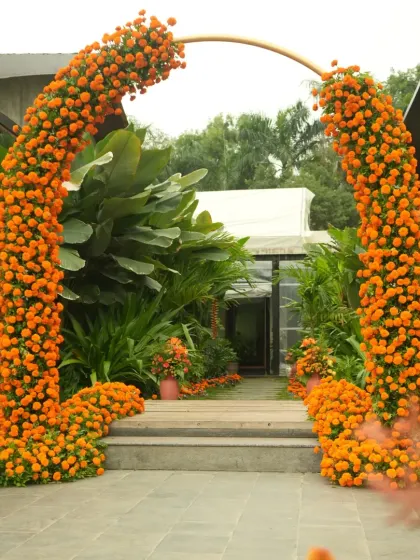 A grand entrance arch for the Haldi ceremony, completely covered in bright orange marigolds, creating a stunning first impression.