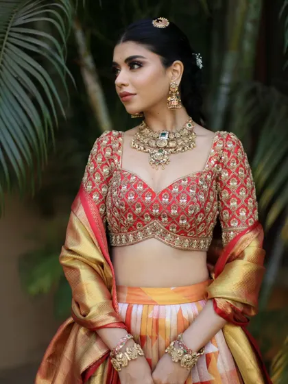 A stunning collaboration featuring a beautiful ikkat-style lehenga. The look is completed with an antique-finish choker and matching bracelets.