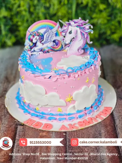 A dreamy unicorn cake with pink and blue frosting. This design features two unicorns under a rainbow, surrounded by clouds, perfect for a magical celebration.