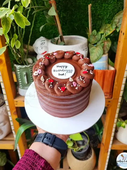The charm of a simple chocolate cake is just unbeatable. This one, with its clean lines and piped border, is a classic for a reason.