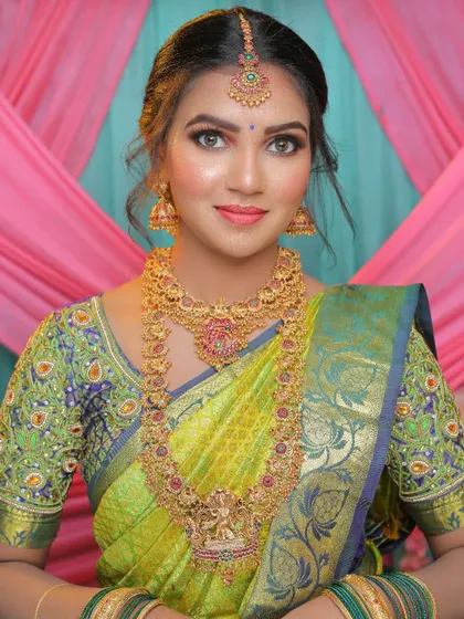 This bride looks so elegant in her green silk saree and traditional temple jewellery. The layered haram and choker set is a perfect choice for a grand celebration.