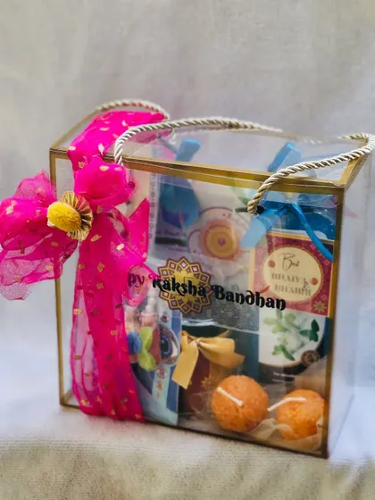 A stylish clear box hamper for Rakhi, perfect for showcasing the curated items inside.