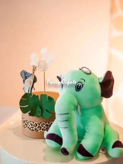 A cute plush elephant and other themed props on the dessert table. Soft toys and other small details add a touch of sweetness to the 'Wild One' theme.