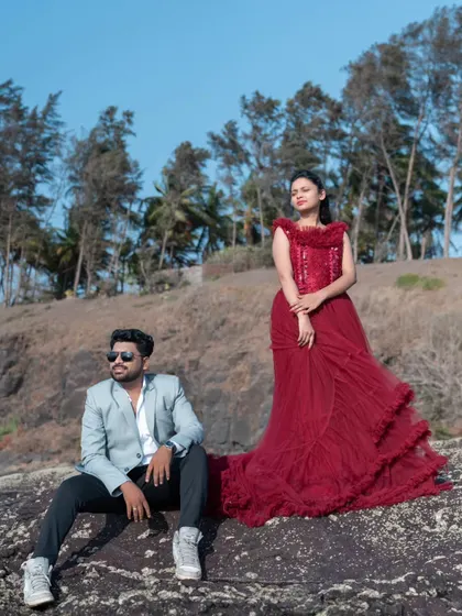 A cool and stylish pose by the sea. The bride's textured red trail gown and the groom's light blazer create a modern and fashionable look for their pre-wedding shoot.