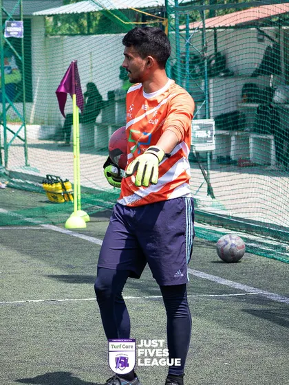 A goalkeeper, alert and ready, stands guard at his post. The keepers are often the heroes of the day in these tight matches.