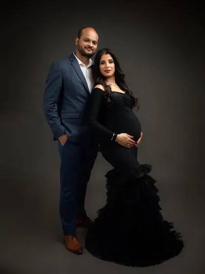 A classic full-length portrait of a couple dressed in elegant black. This timeless pose is perfect for a more formal maternity look.