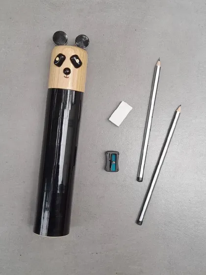 The 'Cuddles' the panda pencil box, complete with pencils, an eraser, and a sharpener. It's a functional and adorable gift, handcrafted using Channapatna techniques.