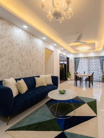 A textured wallpaper accent wall adds depth and interest to the living room, complementing the bold colors of the furniture and rug.