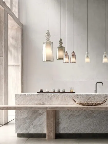 A linear arrangement of the Matteo Ugolini pendants over a minimalist stone counter. This shows how they can be used to create a simple, elegant rhythm in a space.
