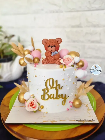 Another sweet "Oh Baby" cake for a baby shower. This one combines a cute teddy bear with soft pink roses, gold spheres, and dried botanicals for a chic and modern look.