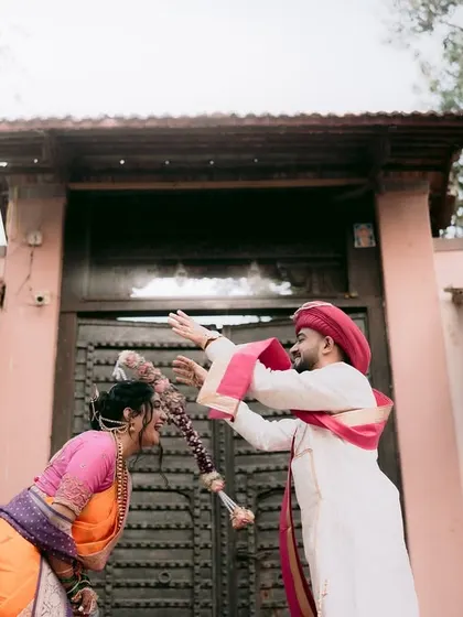 A playful moment between the couple in front of a traditional wada, or ancestral home.