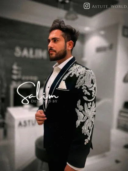 A side view of a client in a black tuxedo with heavy silver floral embroidery on the shoulder and sleeve. The detail in the threadwork is a testament to my team's craftsmanship.