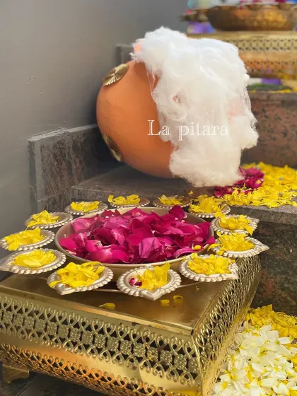 A traditional element for the welcome ceremony, featuring a pot of 'makhan' (butter) and a platter of diyas with fresh flower petals, symbolizing auspiciousness and divine blessings.