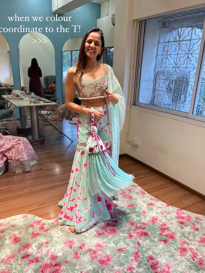 A client trying on a beautiful color-coordinated sharara set. The way the floral print on the rug matches her outfit is a happy coincidence that shows how inspiration can be found everywhere.