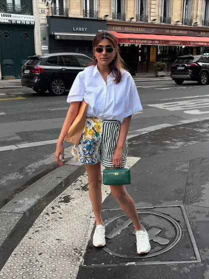 A classic Paris street style look. A simple white shirt paired with printed shorts and white sneakers is my formula for a chic and comfortable day of exploring.