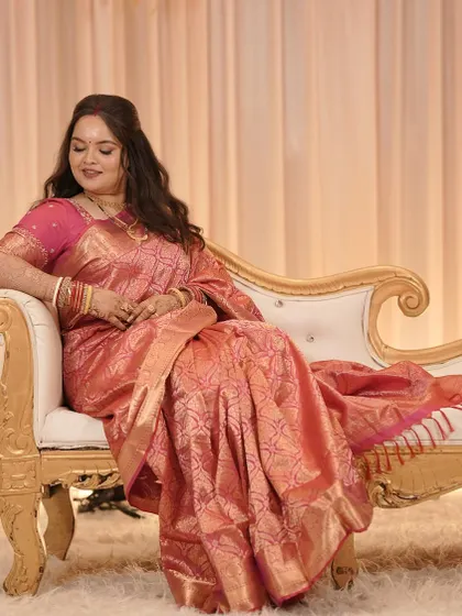 A relaxed portrait of our Bengali bride at her reception, looking elegant in a pink saree.