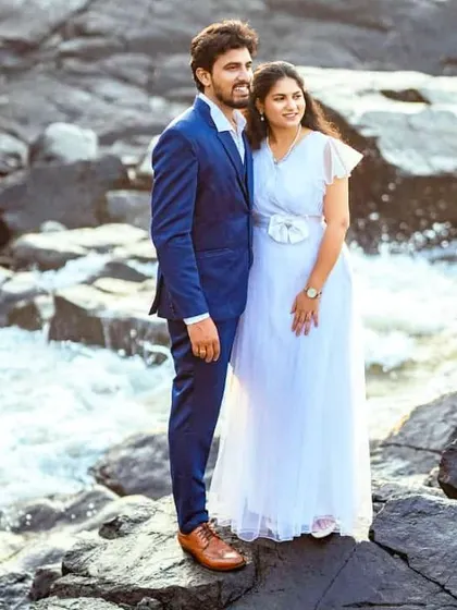 A perfect summer pre-wedding look by the water. She wears a simple and elegant white gown, while he complements her in a sharp blue suit. This combination is fresh, modern, and effortlessly romantic.