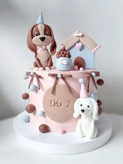 A sweet cake celebrating a puppy's second birthday, complete with a doghouse and adorable fondant dogs.