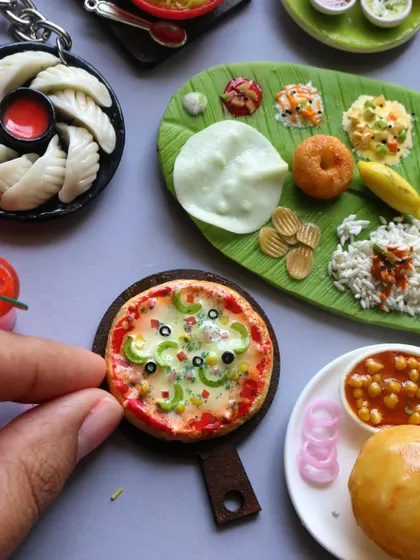 A close-up of a miniature pizza, showing the detailed toppings like bell peppers, olives, and melted cheese.