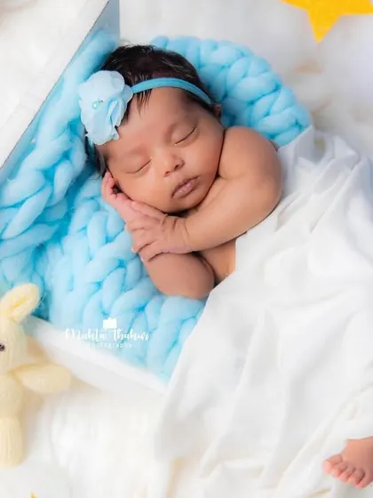 A perfect little angel sleeping in her heavenly bed. The soft lighting and cozy props ensure your baby is comfortable and content.