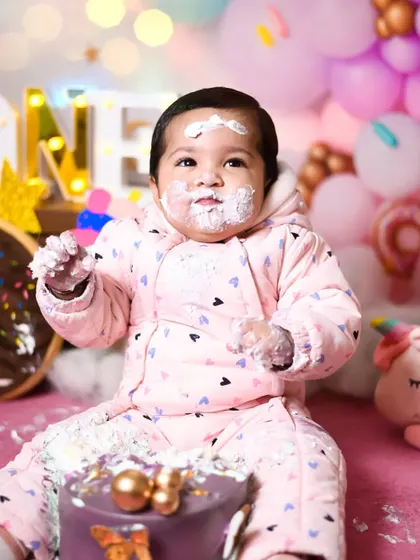 A close-up of Prisha enjoying her birthday cake, with frosting on her hands and face. These are the details you'll want to remember.