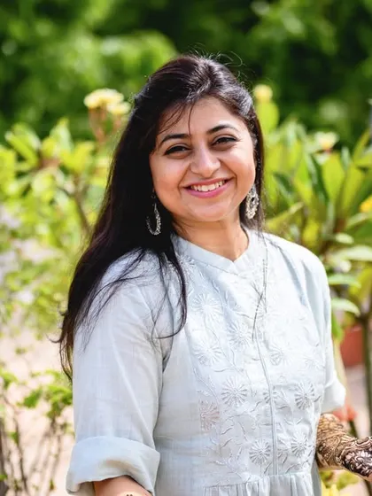 A beautiful, smiling portrait of the bride to be, Poorva, in her lovely terrace garden during her mehendi.