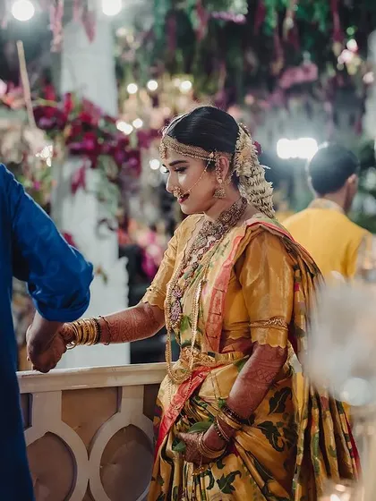 A candid shot of the bride during her traditional ceremony. The warm glow of the candles and the rich colors of her saree create a timeless and beautiful image.