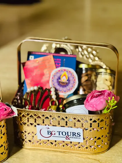 A corporate Diwali gift basket created for 'BG Tours & Travels'. The company's logo is prominently displayed on the front of the ornate metal basket.