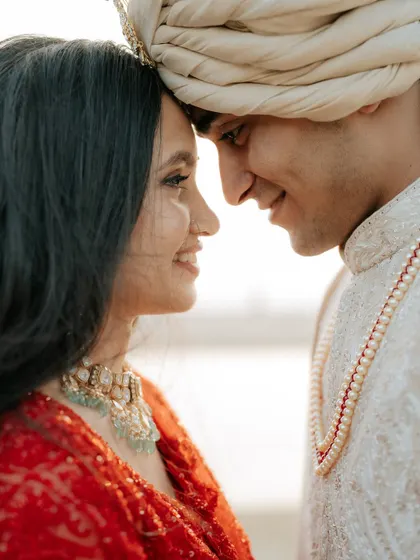 A beautiful close-up portrait, focusing on the couple's happy expressions and the intimate forehead-to-forehead pose.
