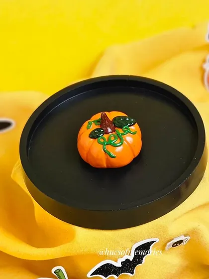 Another angle of the pumpkin trinket tray, showing the detail on the tiny pumpkin figurine.